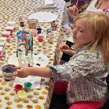 Girl painting a vase at the Service Dog Awareness event at Paint for Fun in Dover, New Hampshire