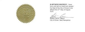 The image shows an official seal and certification statement.

On the left side, there is a gold embossed seal of the City of Dover, New Hampshire. The circular seal contains detailed engravings and text around the edge, indicating it is the city’s official emblem.

On the right side, there is printed text that reads:

"IN WITNESS WHEREOF, I have here unto set my hand and caused the Seal of the City of Dover to be affixed this 27th Day of August, 2025."

Below this text is a signature line, signed by Robert Carrier, Mayor, City of Dover, New Hampshire.

This appears to be a formal certification or proclamation document authenticated with the mayor’s signature and the city seal.