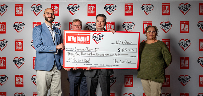 The photo shows four adults standing side by side, Daniel Katsekas, Assistant General Manager, David Madden, executive assistant, Brendan Madden, chairman, and Nicole Poisson, board member. They are posing in front of a branded step-and-repeat backdrop featuring repeated “Revo Casino and Social House” and “Rebels With a Cause” logos. At the center, two people are holding a large ceremonial check. The check is from Revo Casino and Social House, dated 12/9/2025, made payable to Service Dogs NH in the amount of $41,509.86. The written amount reads “Forty One Thousand Five Hundred Nine and 86/100,” and the memo says “#PlayLikeARebel!”. Along the bottom of the check are locations listed: Manchester, Dover, Keene, Lebanon, and Conway. • The person on the far left is wearing a light blue blazer, patterned shirt, and glasses. • The two people in the middle are dressed in business attire and are holding the check. • The person on the far right is wearing glasses and a green sweater.